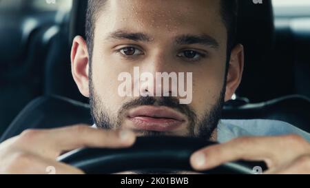 homme fatigué avec la voiture de conduite de front sueur tout en souffrant de la chaleur, image de stock Banque D'Images