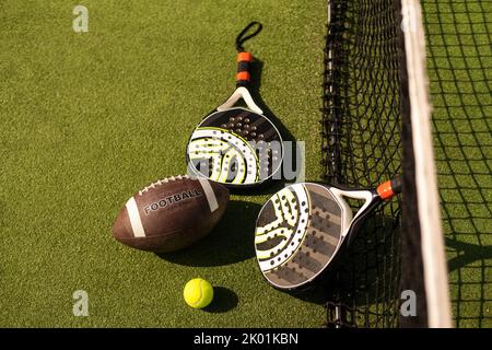 Ensemble d'équipements de sport au sol, padel tennis, ballon de rugby Banque D'Images