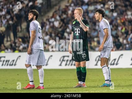 Bakou, Azerbaïdjan – 3 août 2022. Le défenseur Ferencvaros Rasmus Thelander avec les joueurs de Qarabag Bedavi Huseynov et Bahlul Mustafazada pendant le champ de l'UEFA Banque D'Images