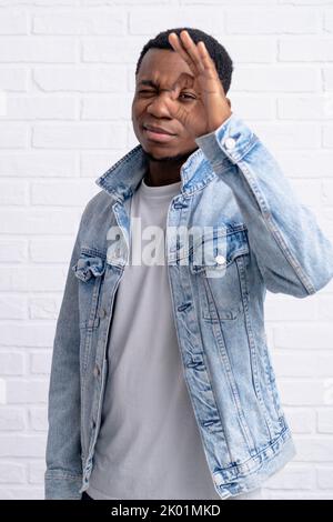 Portrait jeune beau africain noir homme montrant ok geste portant Jean veste denim contre la brique avec mur extérieur avec copyspace. Banque D'Images