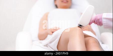 Banner Diode épilation laser, Beauticien enlève les cheveux sur de belles jambes femelles, épilation pour une peau lisse, procédure laser au studio de beauté ou Banque D'Images
