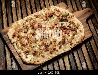 Pizza rectangulaire Flamkuchen tarte flambee avec bacon et poulet sur fond de table en bois Banque D'Images