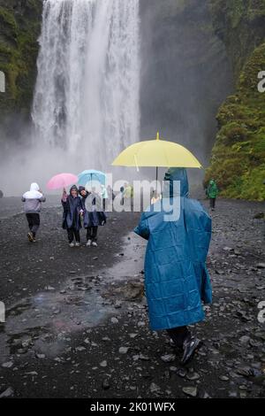 Touristes posant pour des photos à Skogafoss, Islande Banque D'Images