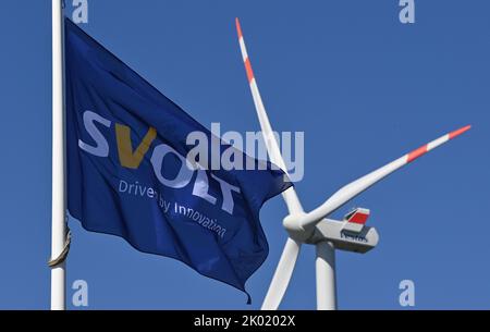 09 septembre 2022, Brandebourg, Lauchhammer : drapeau du fabricant de batteries Svolt vole dans le vent devant une éolienne sur l'ancien site de l'usine Vestas. La société SGV a repris le site de Vestas à Lauchhammer pour produire des batteries ici. Volt est une société mondiale de haute technologie appartenant au constructeur automobile chinois Great Wall Motors. La société développe et produit des batteries au lithium-ion et des systèmes de batteries pour véhicules électriques ainsi que des systèmes de stockage d'énergie. Svolt emploie environ 12 000 personnes dans le monde, dont 3 000 dans la recherche et le développement. Photo: Patrick Pleul/dpa Banque D'Images