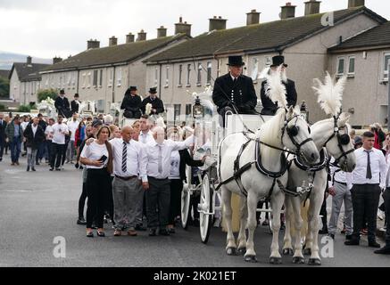 Les amateurs marchent derrière trois corbillards tirés par des chevaux portant les cercueils de Lisa Cash, 18 ans, et ses frères et sœurs jumeaux de huit ans, Christy et Chelsea Cawley, après leur service funéraire à l'église St Aidan, Brookfield, Tallaght. Date de la photo: Vendredi 9 septembre 2022. Banque D'Images