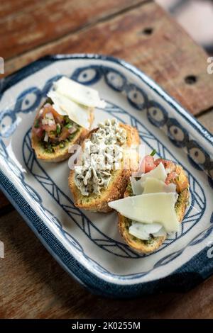 Tapas avec bruschetta et fromage aux herbes crémeux sur toast dans un restaurant rustique Banque D'Images