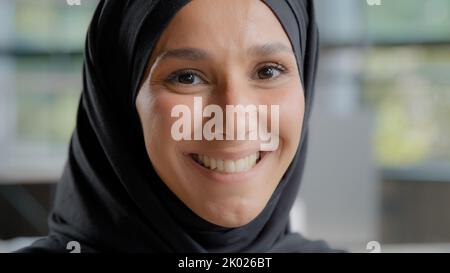 Photo d'une jeune femme arabe attirante dans un hijab regardant un appareil photo belle fille musulmane avec maquillage naturel posant un portrait à l'intérieur heureux islamique Banque D'Images