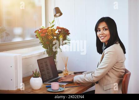 Travailler à domicile a ses avantages. Portrait d'une femme travaillant à son ordinateur portable dans un bureau à domicile. Banque D'Images