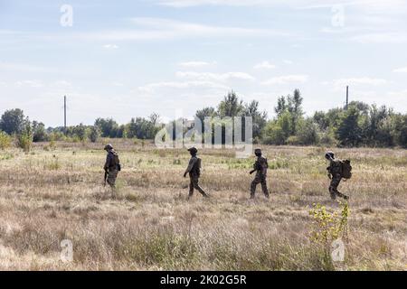 KIEV REG., UKRAINE - 08 septembre 2022 : un groupe d'hommes militaires est vu sur le terrain lors d'un essai d'un robot d'évacuation qui sera utilisé à des fins d'évacuation sur la ligne de front Banque D'Images