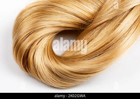 Cheveux blonds noués sur fond blanc Banque D'Images