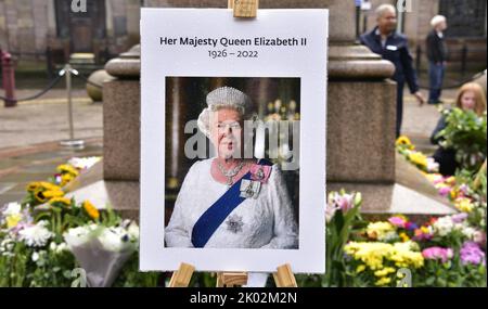 Manchester, Royaume-Uni, 9th septembre 2022. Une photo de sa Majesté la reine Elizabeth II, avec des fleurs laissées sur la place St Ann, Manchester, Royaume-Uni. La période de deuil commence après la mort de sa Majesté la reine Elizabeth II, à Manchester, au Royaume-Uni. Le Conseil municipal de Manchester a déclaré sur son site Web que la ville de Manchester observe la période officielle de deuil de 10 jours et que : « les résidents peuvent souhaiter déposer des fleurs pour marquer la mort de sa Majesté. Vous pouvez déposer des fleurs sur la place St Ann. Crédit : Terry Waller/Alay Live News Banque D'Images