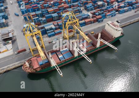 Nakhodka, Russie - 5 août 2022: Piles de conteneurs et de navires de mer dans le port, la vue de dessus. Banque D'Images