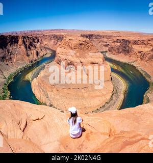 Une vue arrière d'une fille avec des vêtements blancs à Horseshoe Bend à page par une journée ensoleillée Banque D'Images