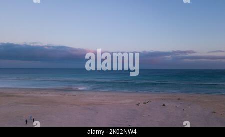 Coucher de soleil sur la plage avec skt et océan bleu en arrière-plan vu d'en haut. Concept de beau paysage de côte et les gens qui se mordu sur le sable. Vacances d'été destination de voyage Banque D'Images