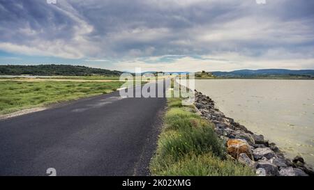 La route nationale D 105 traverse l'Étang de Saint Paul près de Bages. La commune est située dans le Parc naturel régional Narbonnaise en Méditerranée. Banque D'Images