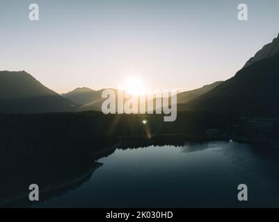 Le soleil brille au-dessus de la forêt verte avec ses collines et son lac Banque D'Images