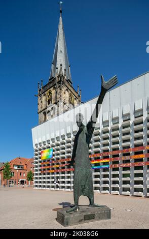 Allemagne, Ahaus, Westmuensterland, Muensterland, Westphalie, Rhénanie-du-Nord-Westphalie, Église catholique St. Mariae Himmelfahrt au marché, le clocher vient de l'ancienne église et la nef a été ajoutée comme un bâtiment en béton par Erwin Schiffer, en face de lui la sculpture « Der Mahner » de Hilde Schuerk Frisch Banque D'Images