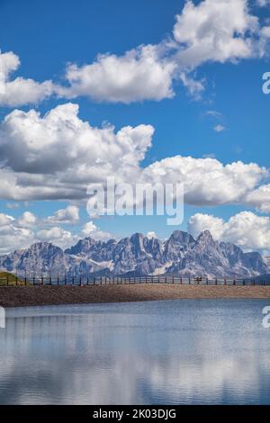 Italie, Trentin, province de trente, Predazzo, vallée de Fiemme. Lac artificiel, réserve d'eau pour la fabrication de la neige des pistes de ski, en arrière-plan la chaîne de montagnes du Pale di San Martino, Dolomites Banque D'Images