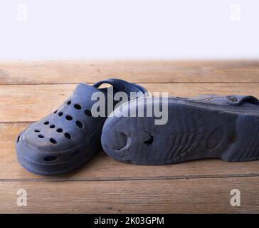 Usure des chaussures en caoutchouc crocs sur un blanc Banque D'Images