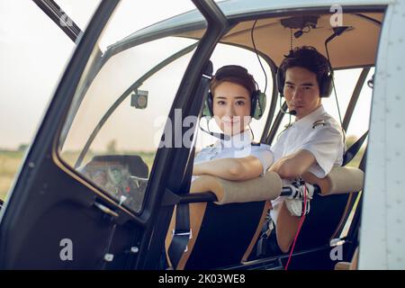 Pilotes chinois assis dans un poste de pilotage d'hélicoptère Banque D'Images
