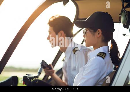 Pilotes chinois assis dans un poste de pilotage d'hélicoptère Banque D'Images