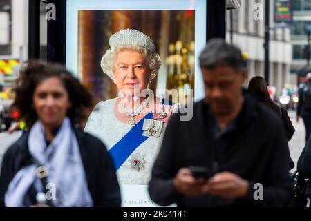 Londres, Grande-Bretagne. 9th septembre 2022. Des gens marchent devant un écran commémorant la reine Elizabeth II de Grande-Bretagne à Londres, en Grande-Bretagne, le 9 septembre 2022. La reine Elizabeth II, le monarque le plus ancien de l'histoire britannique, est décédée à l'âge de 96 ans, a annoncé jeudi le palais de Buckingham. Credit: Stephen Chung/Xinhua/Alay Live News Banque D'Images