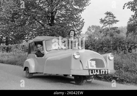 Photographie d'époque en noir et blanc prise en 1950s avec leur couple de 3 roues Bond Minicar Mark C, enregistrement LUJ 177. Prise en Angleterre. Banque D'Images