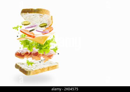 Hamburger avec légumes, légumes verts, viande sélectionnée et tranches de pain dans un vol gelé sur fond blanc. Minimalisme. Abstraction. Il n'y a pas de peop Banque D'Images