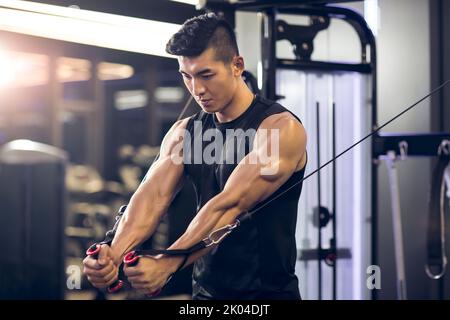 Jeune homme d'origine chinoise de l'exercice à la salle de sport Banque D'Images