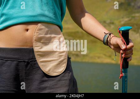 femme randonnée avec un sac d'ostomie dans les montagnes Banque D'Images