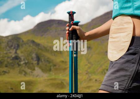 Femme avec sac de colostomie dans les montagnes avec un lac Banque D'Images