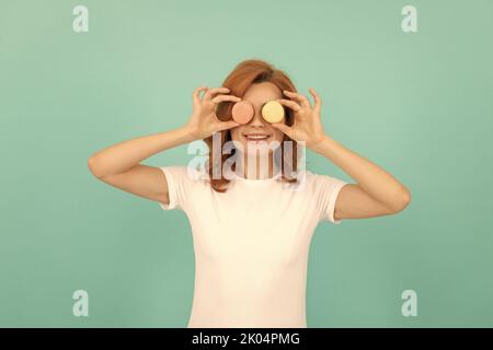 drôle femme tenir doux macaron cookie français sur fond bleu Banque D'Images