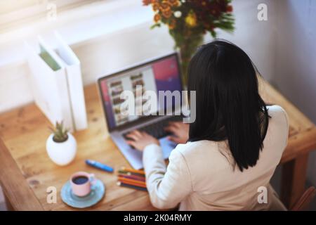 Le travail à domicile a ses avantages : une femme travaillant à son ordinateur portable dans un bureau à domicile. Banque D'Images