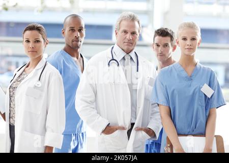 Sérieux au sujet de vos besoins médicaux. Équipe de professionnels de la santé debout ensemble. Banque D'Images