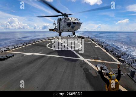 MER DES PHILIPPINES (août 31, 2022) un hélicoptère MH-60K attaché au destroyer de classe Takanami de la Force d’autodéfense maritime du Japon (JMSDF) JS Takanami (DD 110) quitte le pont de vol du destroyer de missile guidé de classe Arleigh Burke USS Higgins (DDG 76) en mer des Philippines, août 31. Higgins participe à des exercices multilatéraux à l’appui du déploiement Indo-Pacifique de la JMSDF, ainsi que de la Marine royale australienne et de la Marine royale canadienne. Des exercices multilatéraux de routine comme celui-ci rassurent nos alliés et partenaires de l'engagement des États-Unis à maintenir un Indo-Pacific libre et ouvert. Higgi Banque D'Images