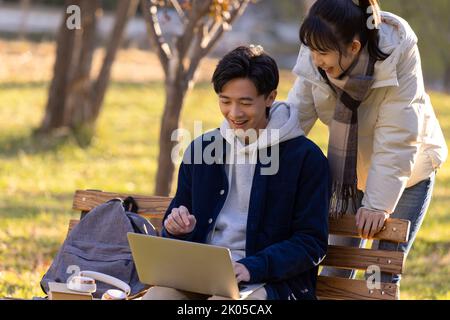 Des étudiants chinois heureux utilisant un ordinateur portable sur le campus Banque D'Images