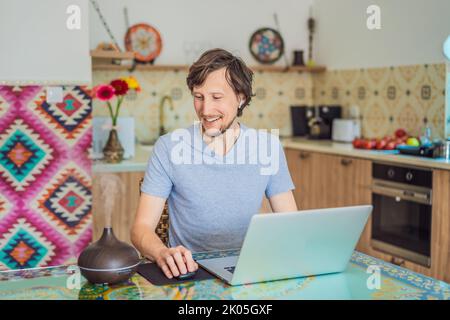 Diffuseur d'huile essentiel sur la table en cours de cuisson pendant que l'homme utilise un ordinateur portable Banque D'Images