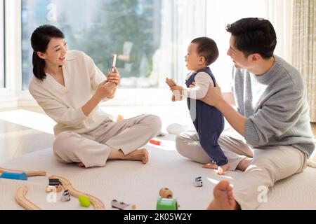 Jeunes parents chinois jouant avec bébé à la maison Banque D'Images