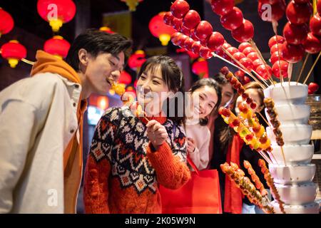 De jeunes amis chinois avec des hardes confites célébrant le nouvel an chinois Banque D'Images