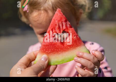 L'enfant mange de la pastèque en été. Mise au point sélective. Banque D'Images