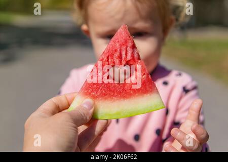 L'enfant mange de la pastèque en été. Mise au point sélective. Banque D'Images