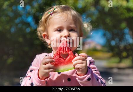 L'enfant mange de la pastèque en été. Mise au point sélective. Banque D'Images