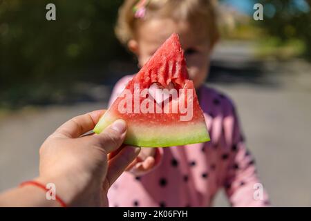 L'enfant mange de la pastèque en été. Mise au point sélective. Banque D'Images