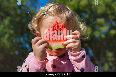 L'enfant mange de la pastèque en été. Mise au point sélective. Banque D'Images