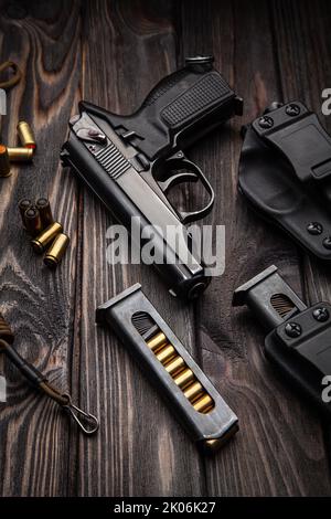 Un pistolet et des munitions modernes noires sur fond de métal sombre. Armes de police, armée, forces spéciales. Banque D'Images