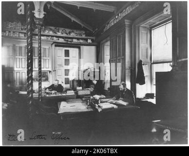 Service des postes - Bureau de la lettre morte, entre 1890 et 1950. Deux hommes et une femme travaillant au bureau. Banque D'Images