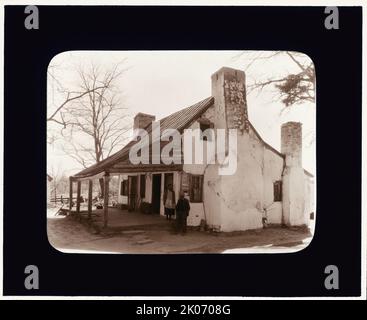 Cabine non identifiée, région de Middleburg, comté de Loudoun, Virginie, entre c1930 et 1939. Homme et femme afro-américains, à l'extérieur, debout au coin d'une maison près de la cheminée. Banque D'Images