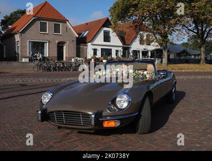 Elburg, pays-Bas - sept 9 2022 Une voiture de location très spéciale pour les mariages : une Jaguar e-type cabriolet. Quelques vieilles maisons hollandaises en arrière-plan Banque D'Images