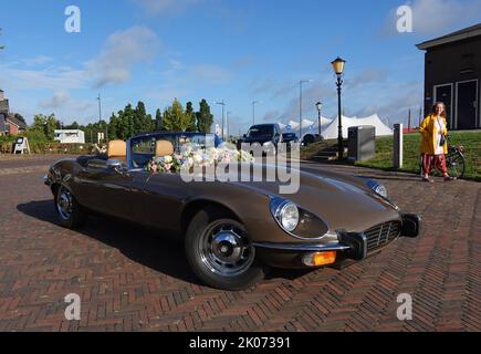 Elburg, pays-Bas - sept 9 2022 Une voiture de location très spéciale pour les mariages : une Jaguar e-type cabriolet. Une femme et un lampadaire en arrière-plan Banque D'Images