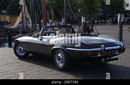 Elburg, pays-Bas - sept 9 2022 Une voiture de location très spéciale pour les mariages : une Jaguar e-type cabriolet. Le vieux port de pêche en arrière-plan Banque D'Images